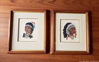 Two framed petit point portraits side by side