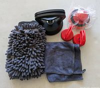 all items overview: large suction puller, two small red pullers, microfiber mitt, microfiber cloth, foam pads