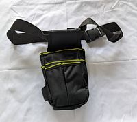 Front view of black tool pouch showing pockets and removable strap