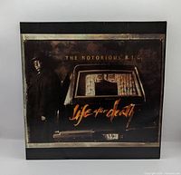 Front gatefold cover depicting artist beside hearse