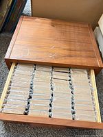 Drawer box opened showing rows of sleeved card sets