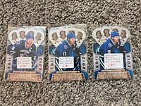 Three sleeved 2011-12 Panini Crown Royale Vancouver Canucks cards laid out on carpet