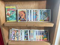 Aquaman comic and two rows of Dinosaurs Attack! cards on shelf
