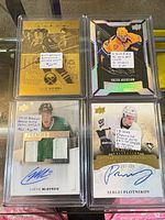 Group shot of all four encased hockey cards showing front designs, patches and autographs