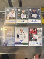 Six top-loaded autographed hockey cards laid out