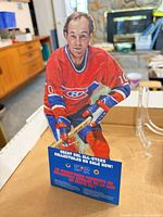 Front view of cardboard standee showing player and base text