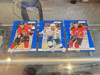 Overview of three Panini Prizm Blue Prizm hockey cards featuring Erik Karlsson, Martin St. Louis, Travis Zajac