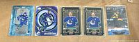 All five sleeved J.T. Miller Upper Deck hockey cards laid out