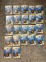 Front view of 23 sealed mini pucks arranged on floor