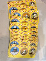 Stack of multiple uncut yellow Zellers Tim Raines sticker sheets