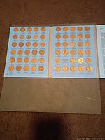 Open album showing two filled panels of cents