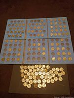 Six blue album panels filled with Jefferson nickels and loose coins spread below