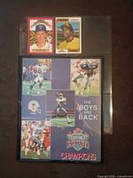 Front view showing two baseball cards in sleeve and framed Cowboys poster