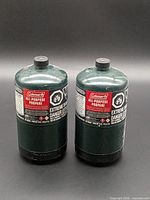 Front view of two Coleman propane cylinders showing labels and caps