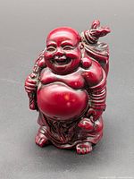 Front view of red resin laughing Buddha figurine