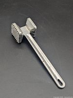 Oblique view of aluminum meat mallet showing textured tenderizing face and handle