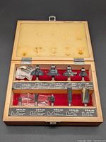 Open case displaying six router bits, labels and interior foam