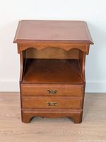 Front view of wooden nightstand showing open cubby and two drawers