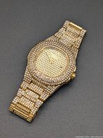 Full view of gold-tone rhinestone-covered wristwatch