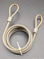 Coiled coated steel cable showing both looped ends