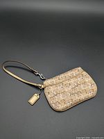 Full view of Coach wristlet with strap and hangtag