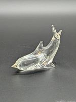 Side view of clear glass dolphin figurine upright