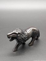 Left front angle of stone lion showing full body and mane detailing