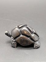 Side view of dark stone turtle figurine