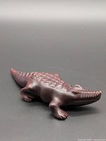 Full view of hand-carved wooden crocodile figurine showing shape and carved details