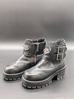 Side view showing both boots, outer straps, logos and overall condition