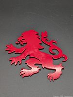 Front view of red metal lion rampant cutout