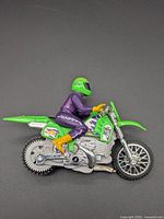 Left side view of Hot Wheels green motocross bike with rider
