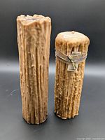 Two large beeswax pillar candles standing upright