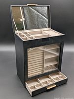 Full view of jewelry box open showing mirror lid, top trays, glass door section, bottom drawer