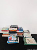Overall view of four stacks of books on black surface against white background