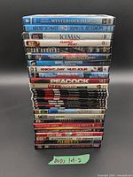 Full stack of DVD cases front view showing 22 spines with green marker tag