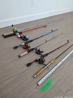 All four rods laid out with attached reels and tape measure for length reference