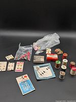 Lot overview showing thread spools, button cards, needle packs, fasteners