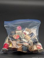 Bag containing numerous sewing thread spools