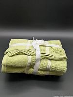 Folded light green towel set tied with white ribbon
