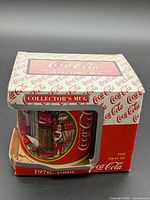 Mug inside original Coca-Cola box showing front graphics