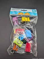 Front view of sealed package showing assorted binder clips and branding