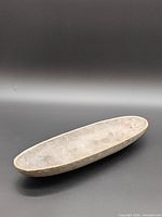 Full view of oblong cement tray on black background