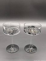Two matching stemmed glass candle holders, front view