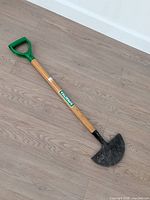 Full view of lawn edger showing blade, handle, grip, and brand label