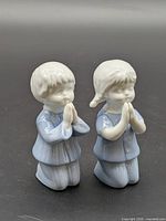 Front view of both kneeling praying figurines