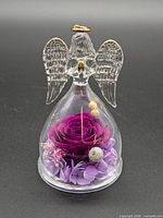 Front view of glass angel figurine encapsulating preserved rose and floral accents