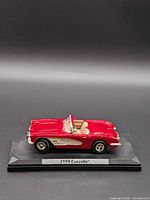Side profile of red 1959 Corvette model on base