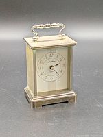 Front view of brass-tone Seth Thomas Cherish carriage clock showing dial and handle