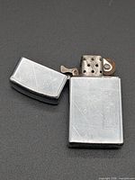 Full lighter open with lid detached showing overall condition